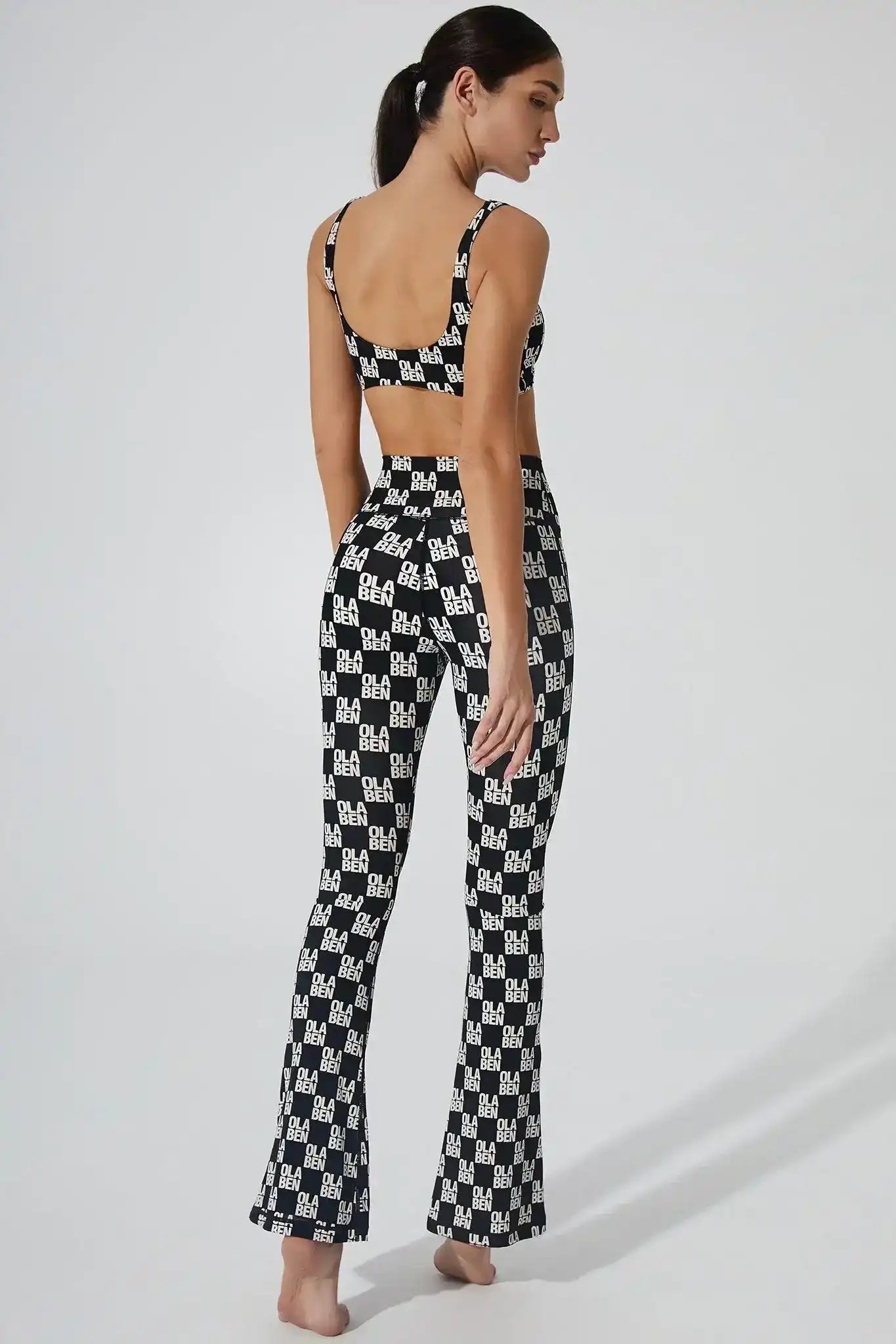Olaben Sera Monogram Flared Legging in Monogram Black — flared monogram-print activewear, full-body shot