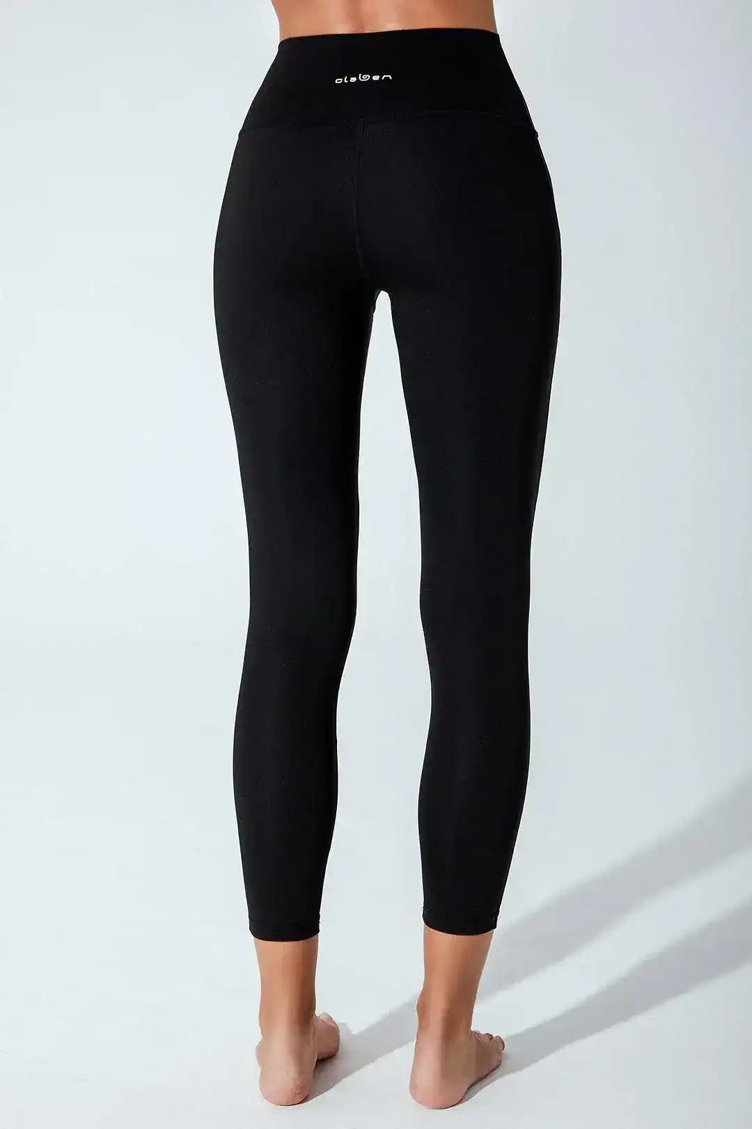 Back view of woman wearing high-waisted black leggings for yoga or fitness
