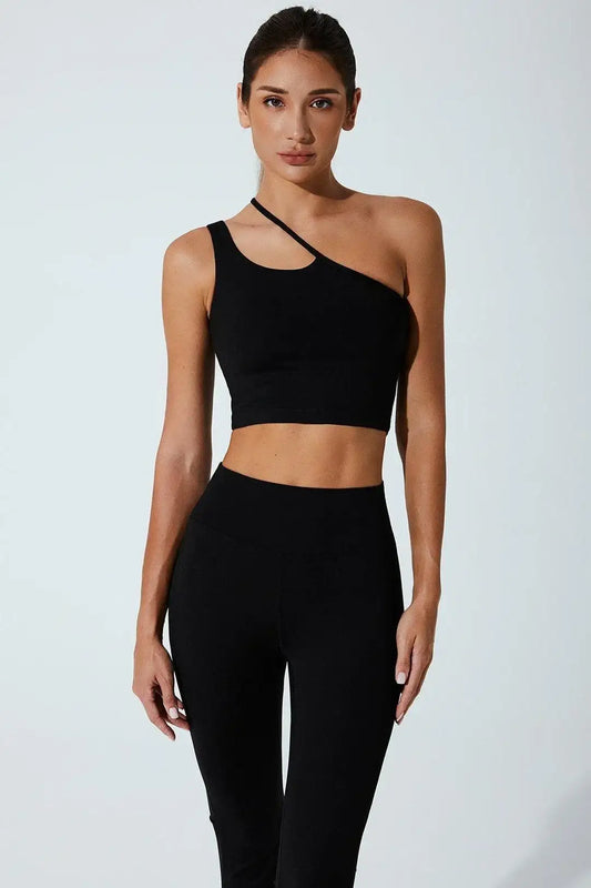Woman wearing black one-shoulder sports bra and high-waisted leggings, activewear fashion
