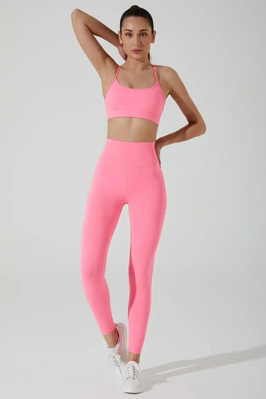 Woman wearing cotton candy pink sports bra and high-waisted leggings set for activewear