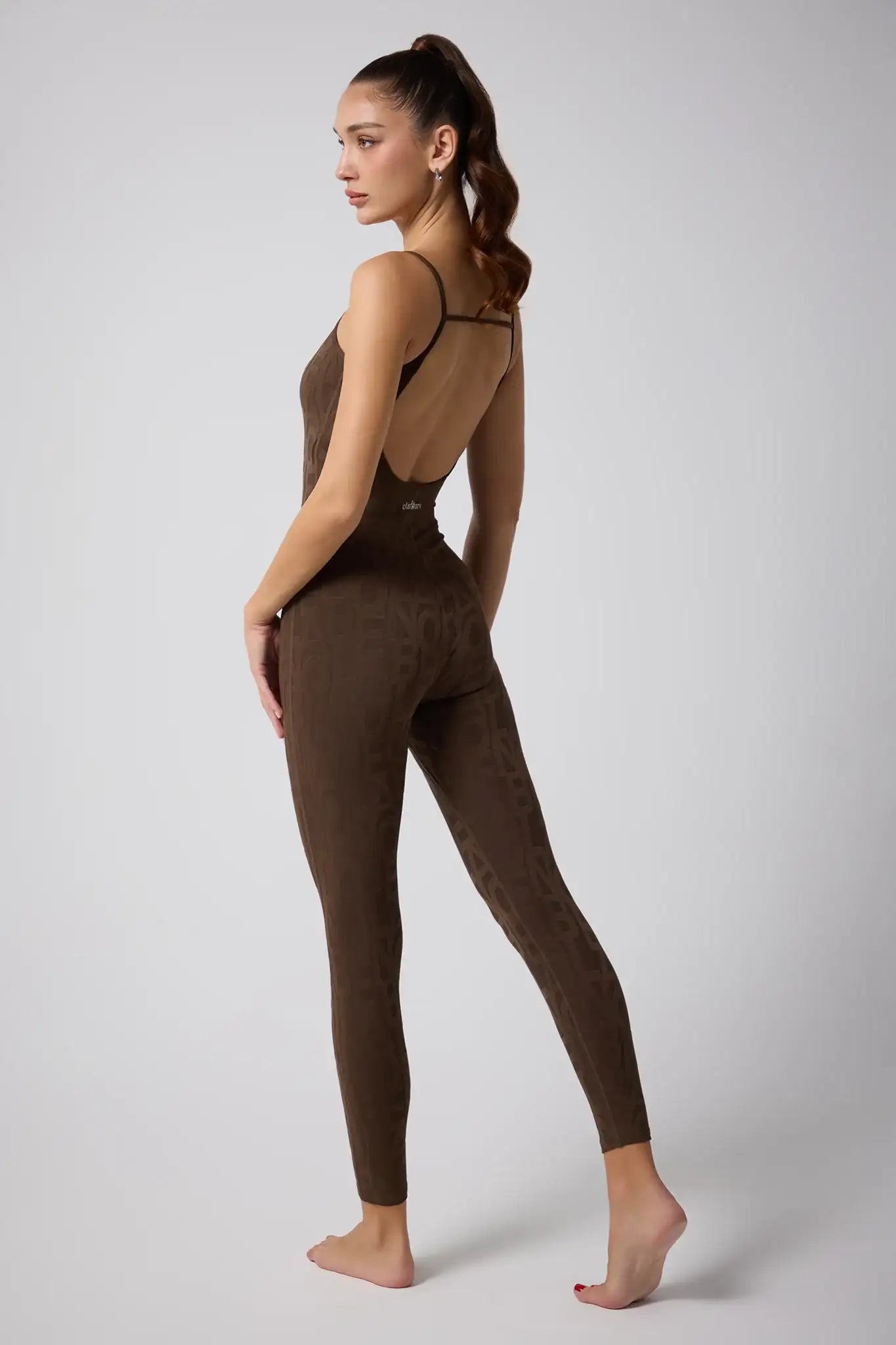 Brown patterned activewear bodysuit with open back, perfect for yoga and fitness workouts.