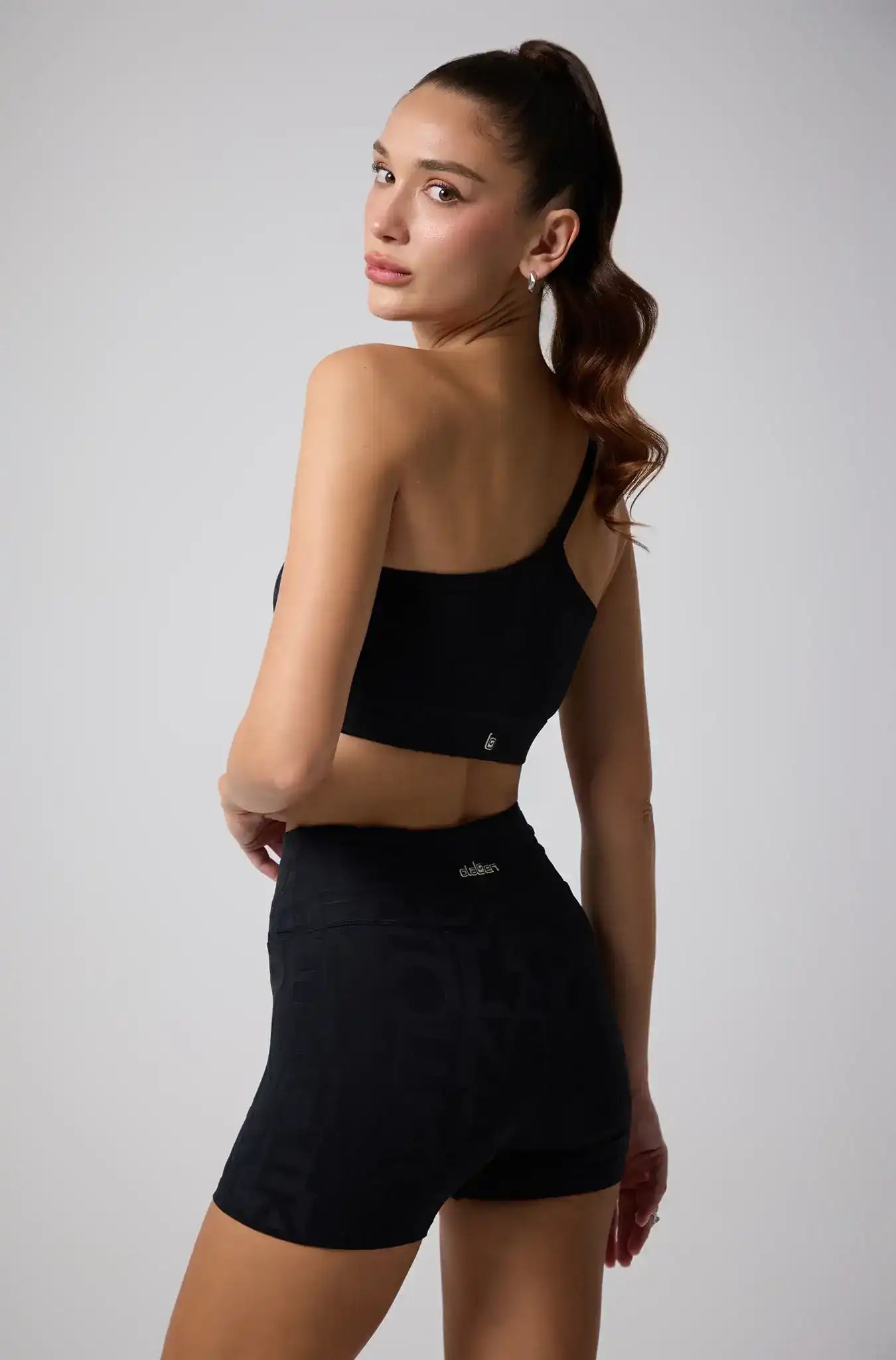 Woman in black activewear sports bra and high-waisted shorts for yoga and fitness workouts