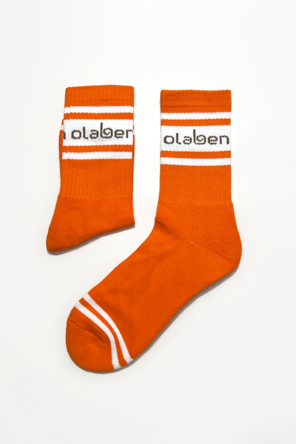 Colorful assortment of socks in sunrise orange shades on a cozy background.