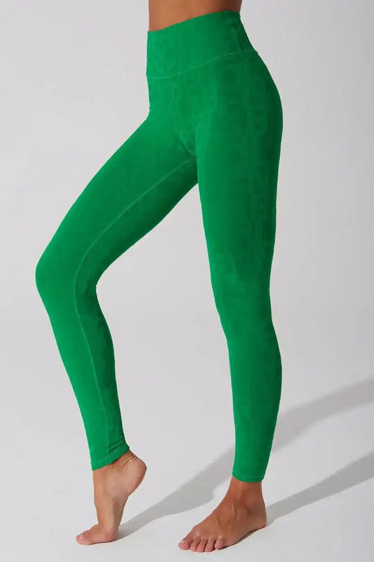 Model in matching Olaben Classic Déese Fleur 3D set — Dark Green embossed leggings and tank top, full-body 3/4 studio shot
