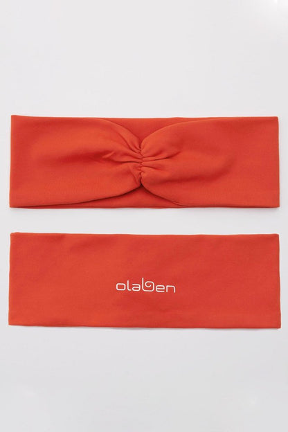 Medium carmine orange headband with OLABEN logo, perfect for stylish headwear enthusiasts.