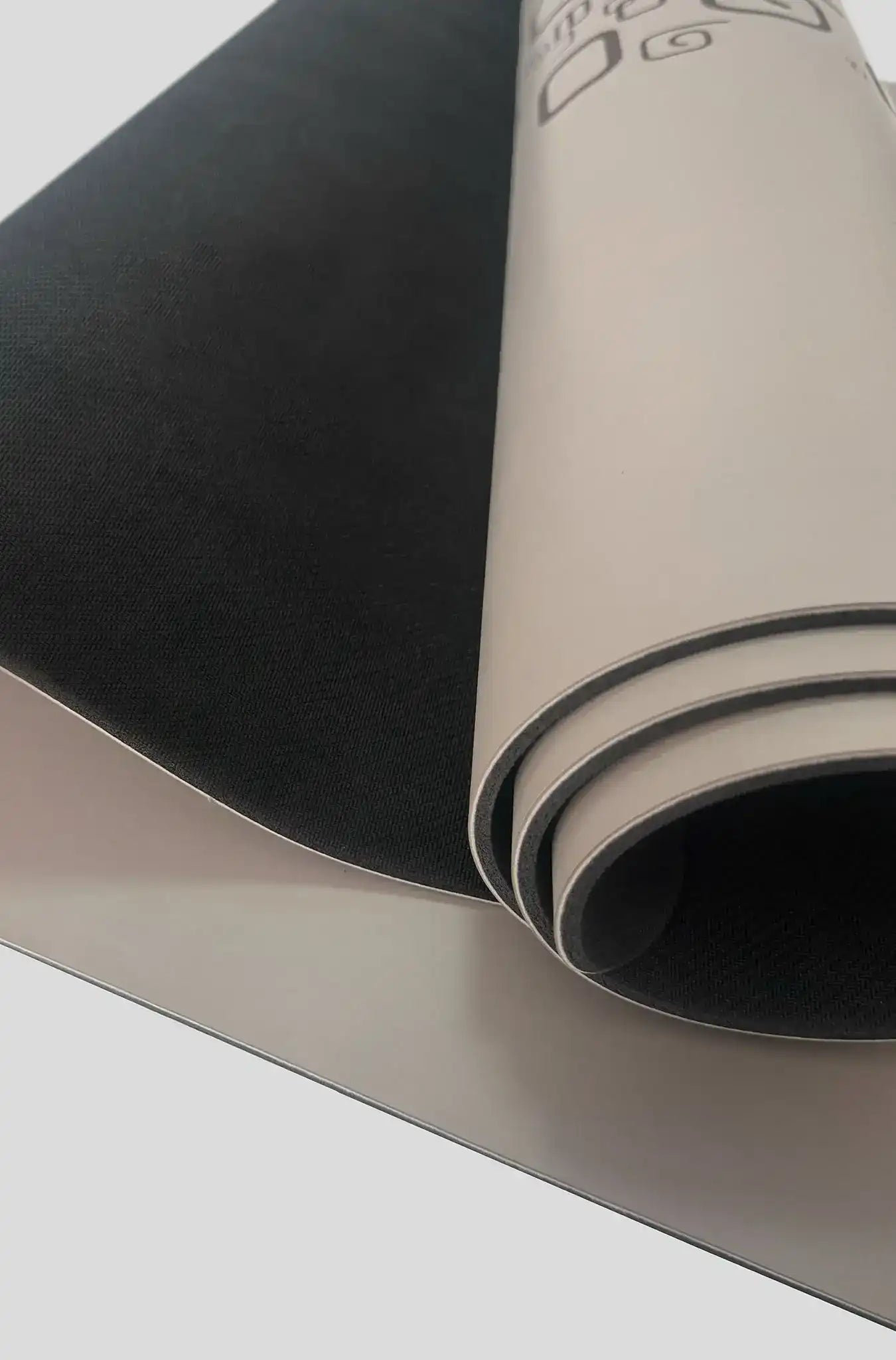 Premium yoga mat with black textured grip surface and light gray rolled design for fitness and studio use