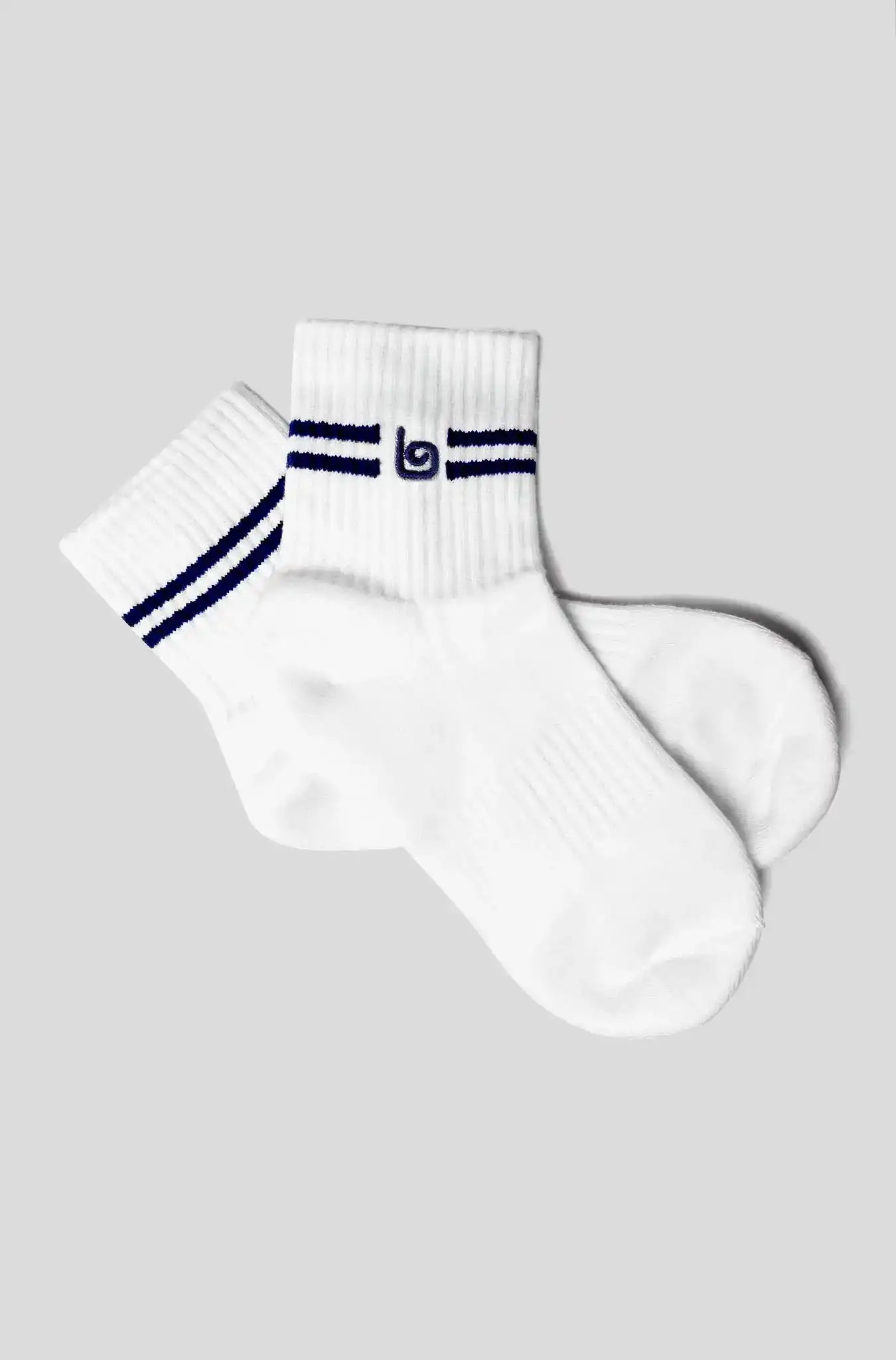 White athletic socks with navy stripes and logo, ideal for fitness and yoga activities.