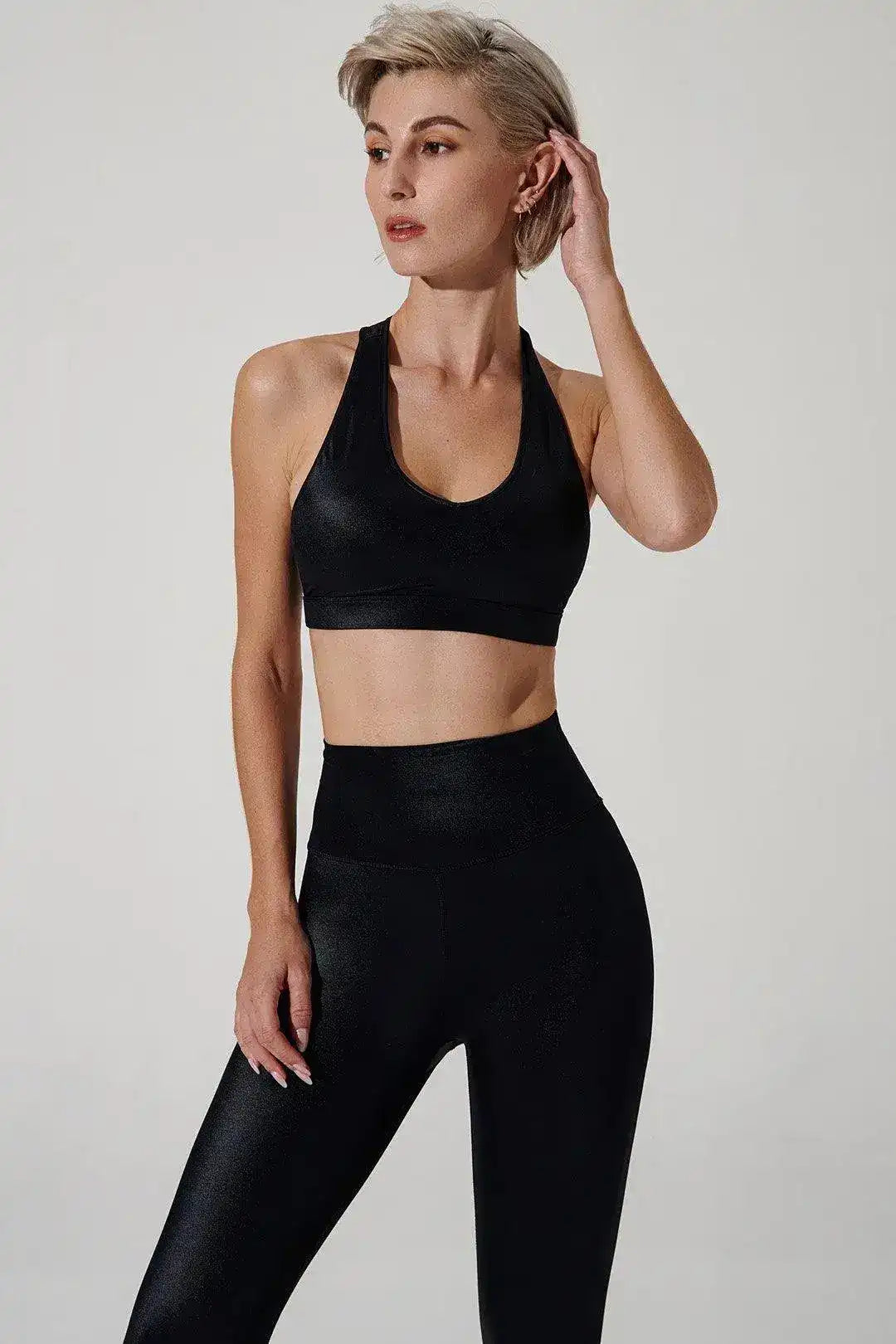 Woman wearing black sports bra and high-waisted leggings, activewear for yoga or fitness