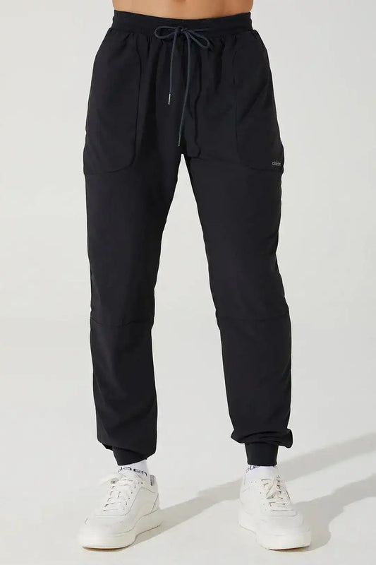 Men's black athletic pants with drawstring waist and front pockets, styled for activewear