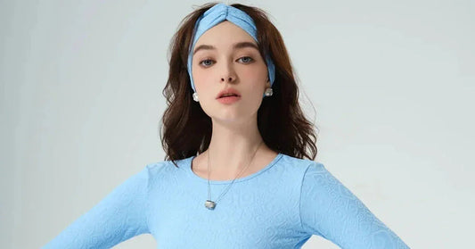 Woman in textured light blue activewear top and matching headband, fitness fashion style