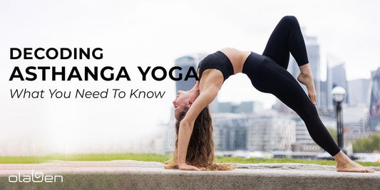 Woman practicing Ashtanga yoga in outdoor urban setting, wearing black activewear.