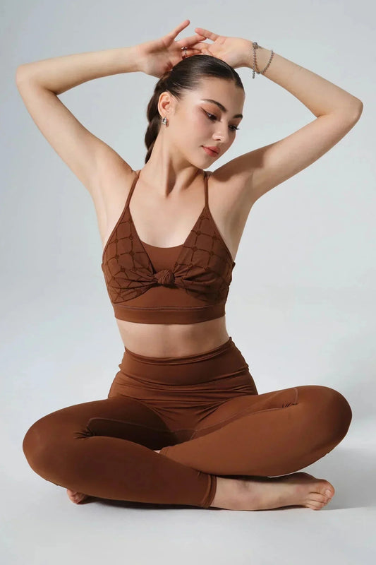 Woman in brown seamless activewear set posing cross-legged, studio background, yoga apparel