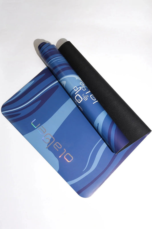Blue yoga mat with abstract wave design, partially rolled on white background