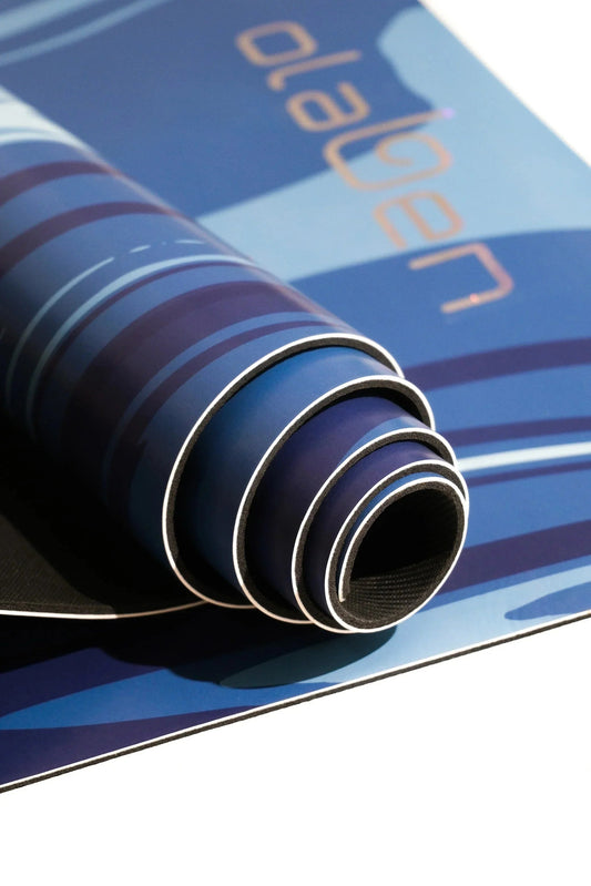 Rolled blue yoga mat with abstract pattern on a flat surface, close-up view