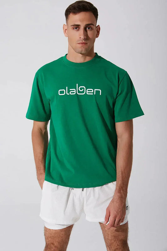 Man wearing green unisex short sleeve tee with bold logo and white athletic shorts