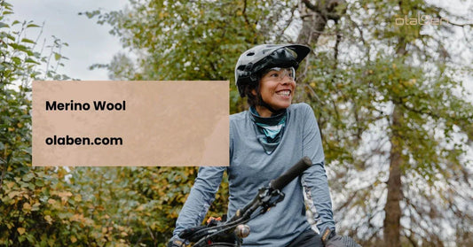 Smiling woman in merino wool activewear riding a bike outdoors in a forest setting