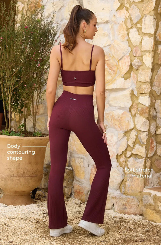 Woman wearing ribbed dark red high-waist flare leggings and crop top outdoors