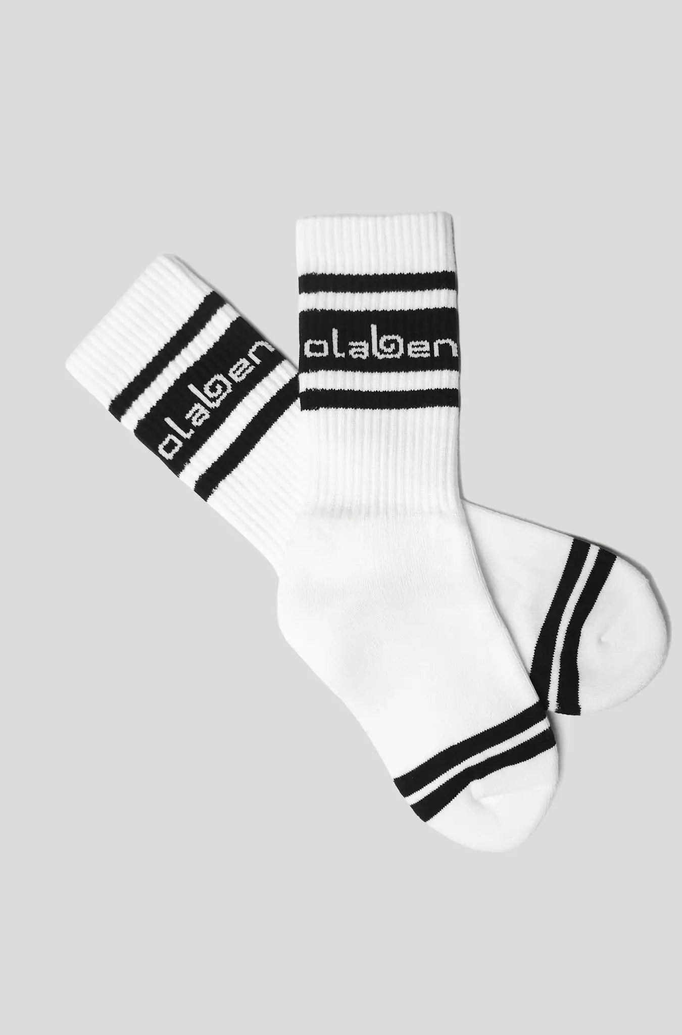 White athletic socks with black stripes and Olaben branding, ideal for fitness and yoga activities.