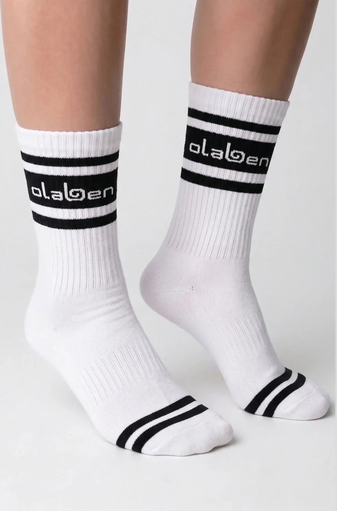 White athletic socks with black stripes and Olaben logo, ideal for fitness and active wear.