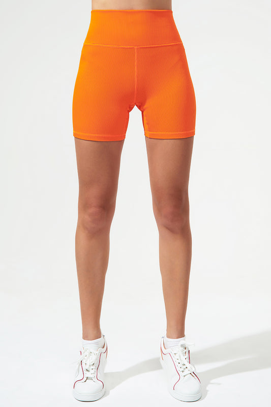 Vibrant tangerine orange women's biker shorts with ribbed texture, perfect for active fashion enthusiasts.