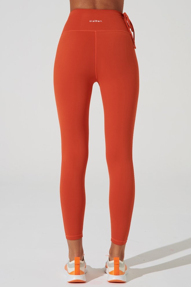Stylish carmine orange women's leggings with mesh detailing, perfect for medium-sized fashion enthusiasts.