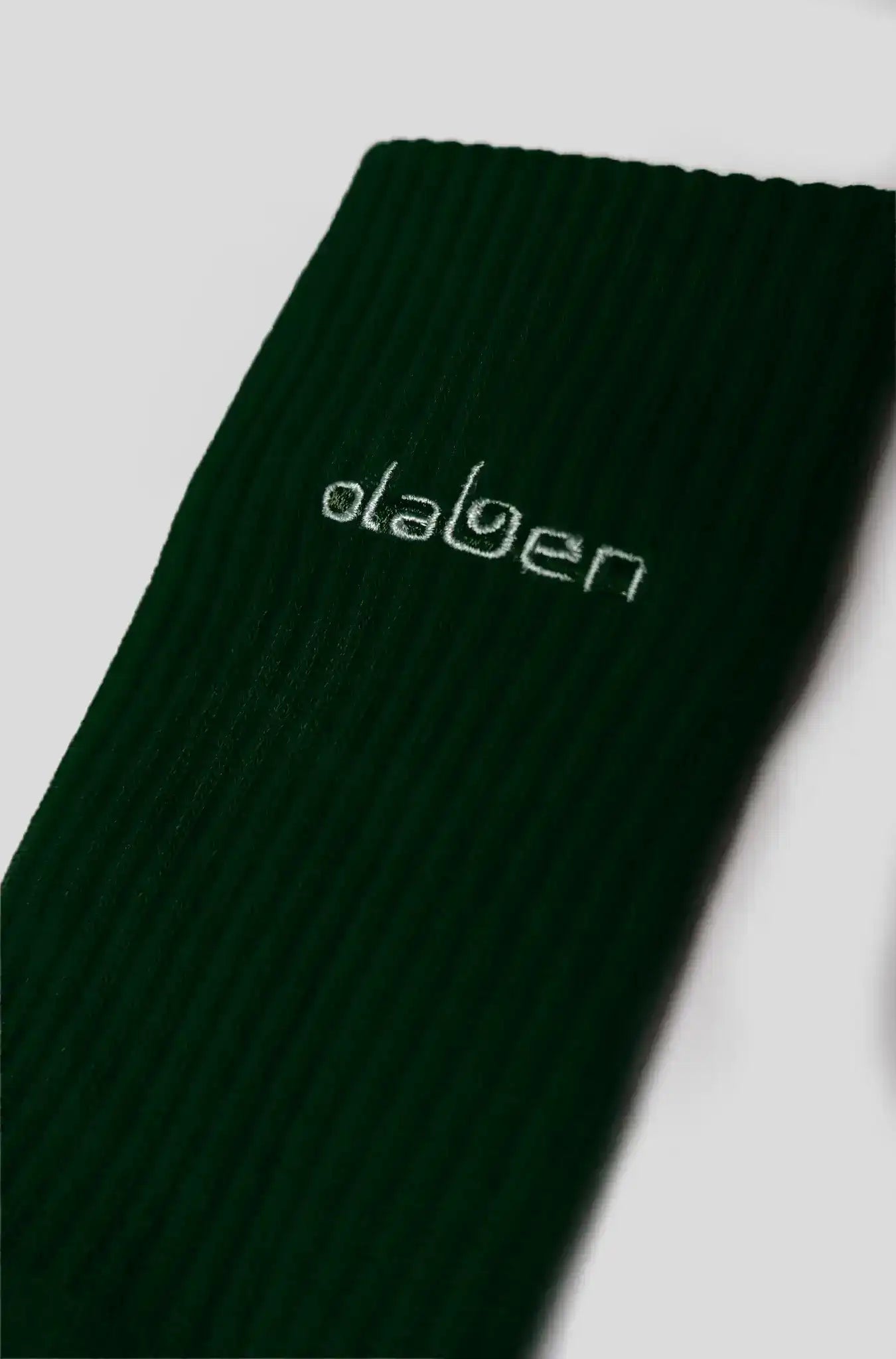 Dark green ribbed activewear sock with embroidered Olaben logo, ideal for yoga and fitness