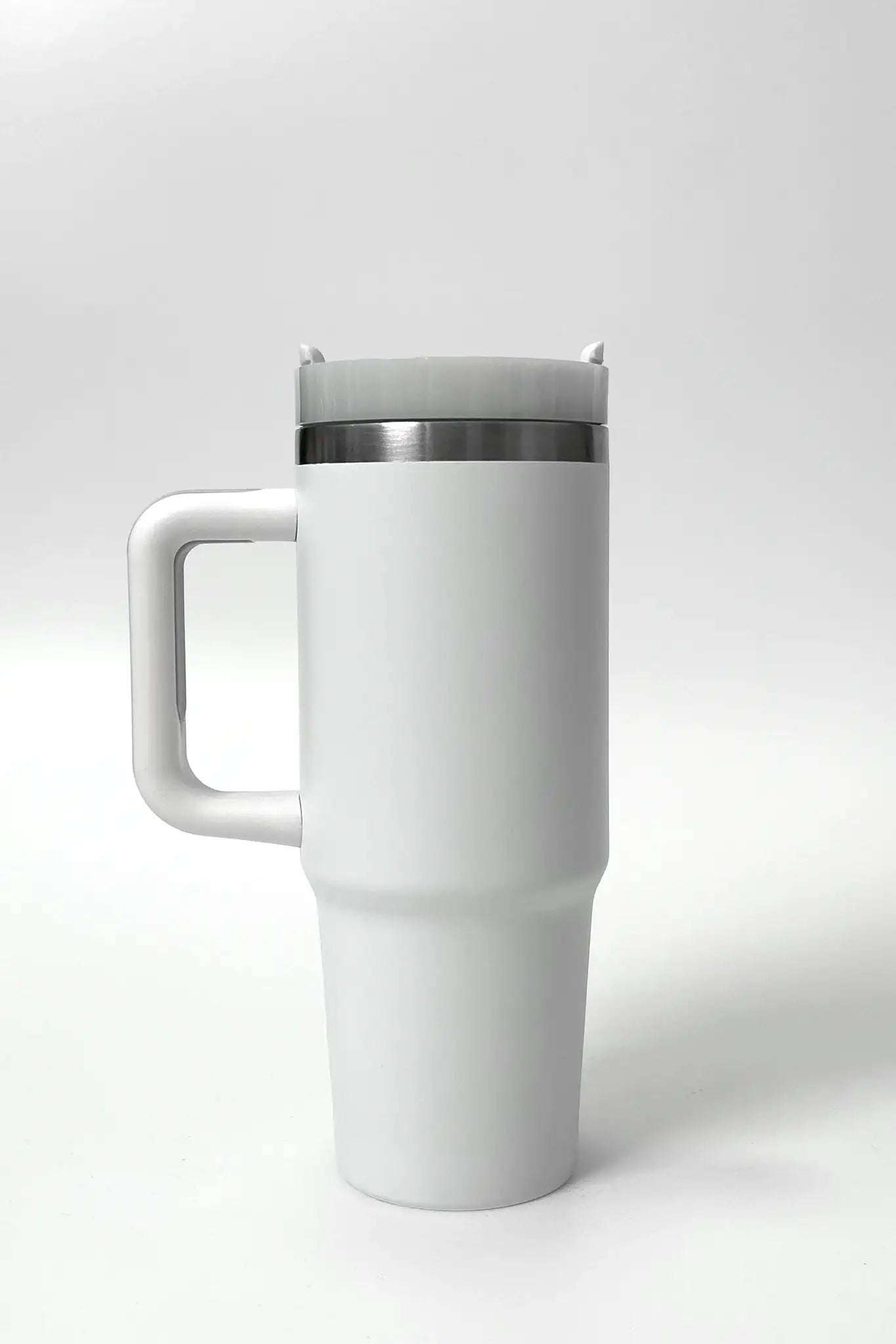 White travel mug with handle and lid, ideal for on-the-go hydration during yoga or fitness routines.
